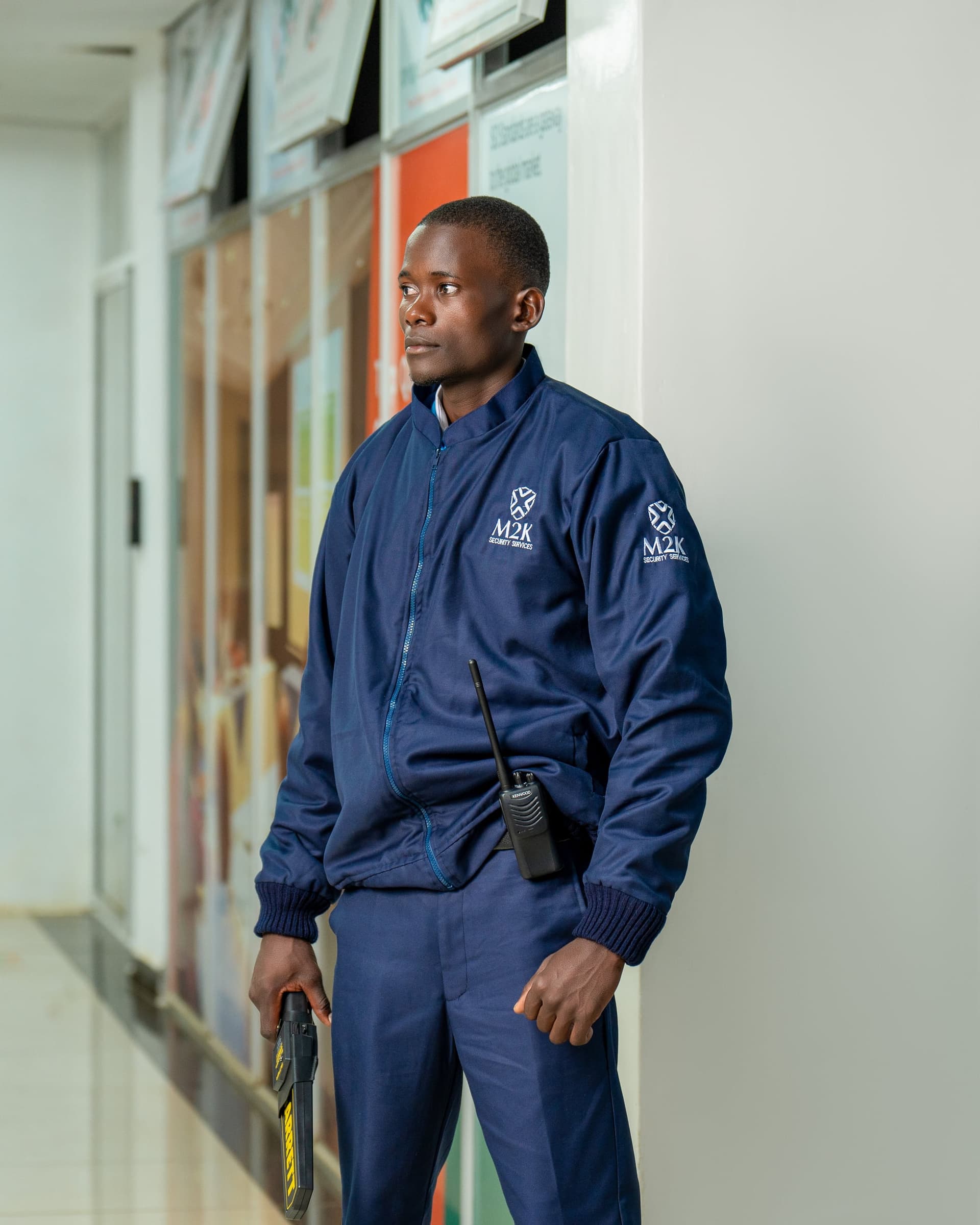 M2K guard standing alert in a building corridor